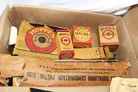 Overview of a box with several vintage Hoppe's gun cleaning products, including four original branded boxes with red and yellow color scheme.