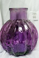 Front view of the large purple glass vase showing the ribbed scalloped design and narrow mouth