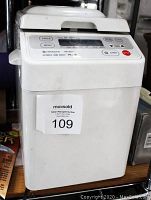 Full view of the front and top of the white automatic bread maker with MaxSold sticker visible