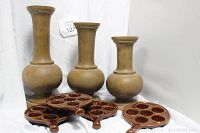 View of the three graded plastic floor posts and four brown ceramic baking plates holding 6 egg slots each with handles.