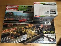 Three boxed Carrera Servo 140 sets stacked, showing Night Rally 75355 and other Carrera Servo 140 boxes with race car images and track graphics.