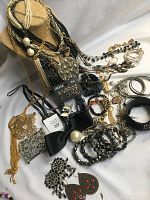 Wide view of assortment of necklaces, bracelets, bangles, earrings, pendants, and hair accessories arranged on a flat surface