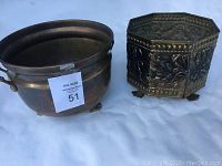 Both brass pots together, showing size and shape differences.