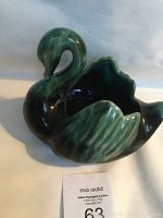 Side view of the Blue Mountain Pottery swan figurine showing green and black glaze with smooth glossy finish and detailed wing texture.