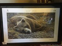 Full view of the framed poster showing the grizzly bear resting on stones and dry grass with signage of 2011 Show of Hearts and Variety charity logos.