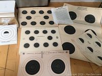 Overview of various paper target sheets showing multiple bullseye targets of different sizes and layouts including one labeled 'Official 50-Yard Small Bore Rifle Target'.