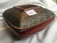 Side angle view of cranberry square plant pot showing the gold and green pattern with visible wear.