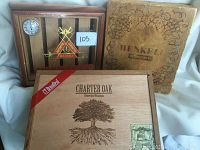 Four vintage cigar boxes: Monte Cristo with temperature gauge and slats, Henkell Pikkolo wooden box with rope tie, and Charter Oak cedar box with slide front and branding.