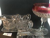 Full view showing sugar bowl with lid, cream pitcher, rectangular butter tray and cover, and wide goblet with cranberry painted top rim.