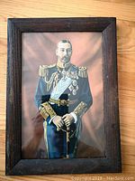 Frontal image of the vintage framed print showing King George V in naval uniform inside dark wooden frame.