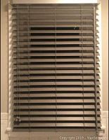 Grey faux wood horizontal slat blind installed in a window