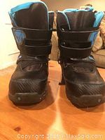 Front view of black Burton snowboarding boots size 6 with blue trim and velcro straps