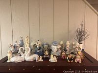 Overview of all figurines displayed on wooden surface against panel wall