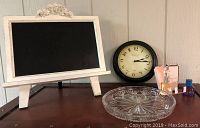 Overall view of the lot showing chalkboard, clock, glass dish and perfumes