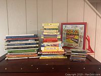 Photo of children's books and two new scrapbooks stacked on a wooden surface.