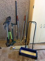 Photo showing full lot including fertilizer spreader, weed trimmer, weed puller, soil rake, snippers/clippers, and corn broom.