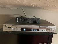 Front view of Sony CD/DVD player with remote placed on top. Display reads NO DISC.