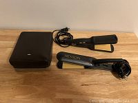 Photo showing Braun leather case and two hair straighteners, one Revlon, one unbranded