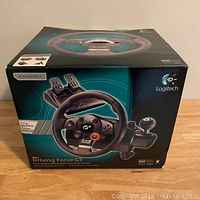 Boxed Logitech Driving Force GT steering wheel and pedals for PS3 showing front of the box with product image and branding.