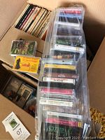 Photo showing boxes filled with cassette tapes and vinyl records, cassette tapes visible in plastic bag