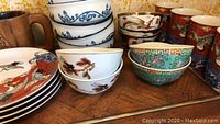 Top view showing stacked bowls and mugs with detailed Asian motifs