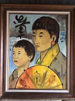 Full view of the oil painting depicting an Asian mother and child holding a fan, framed with a wooden frame.