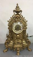Full front view of clock showing overall bronze case and ornate design