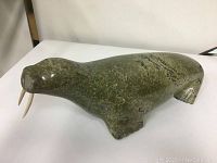 Side view of entire walrus carving on white surface