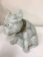 Front side view of the carved stone dog figurine with a metal collar.