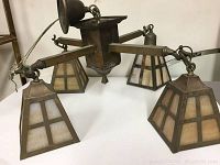 Full view of chandelier showing four slag glass shades and central hub