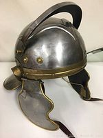 Front-left three-quarter view showing helmet dome, brim and cheek guard