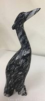Solid marble stone bird figure from side view showing shape and color pattern
