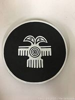 Top view of the round decorative plate showing the black and white Inuit bird design centered on the plate.