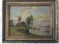 Full view of the framed painting showing the entire lakeside scene including boat, houses, trees, and sailboat on the water.