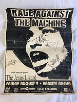 Full view of the black and white Rage Against the Machine concert poster showing graphic face, band name, special guest The Jesus Lizard, event details, and multiple autographs.