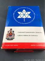 Box front showing the Centennial emblem and Canadian coat of arms with Canadian bilingual text, including 'Centennial Commemorative Stamp Box' and 'Canada Post Office'. The box is primarily blue, white, and red.
