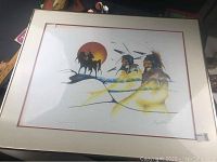 Framed art print showing indigenous veterans with horse and sunset in background, matted and under glass, signed by artist.