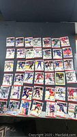 Full overview of 42 hockey cards laid out on black surface showing front of cards with player action shots and Score branding