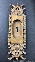 Full view of the key plate showing intricate brass scrollwork and central keyhole