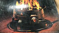 Photo of the firebowl box showing flames and product details including 58,000 BTU output and modern design with vent holes.