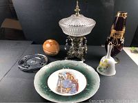 Overview showing all six items in the lot with clear display of different shapes and materials including crystal compote, ruby vase, egg, plate, bell, and souvenir hot plate