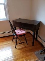 Desk and chair placed beside a window on wooden floor, showing overall appearance.