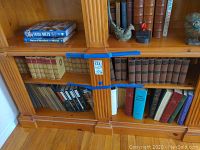 Wide view of wooden shelves with Mark Twain and Charles Dickens book sets.
