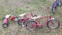 Three children's bikes on grass showing wear and rust