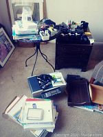 Overall view of multiple office supplies including HP Officejet 5610 printer, staplers, radios, trays and paper stacks in a room.
