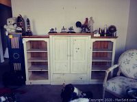 Front view of the complete three-piece entertainment center with various decorative items on shelves (not included).