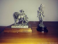 Overview of both pewter sculptures side by side on table