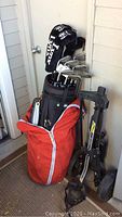Golf clubs set with Lynx headcovers in a black and red travel cover bag