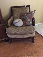 Front view of the arm chair with fabric seat and back, showing the chair's cushions and pillows.