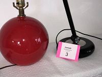 Photo showing the glossy red ceramic ball table lamp base next to the black Park Sherman fluorescent desk lamp base